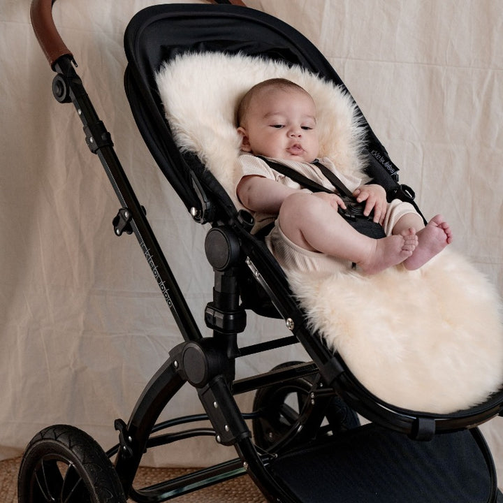 Baby boy in an ickle bubba pram, lined with neutral sheepskin, eco and sustainable sheepskin from New Zealand