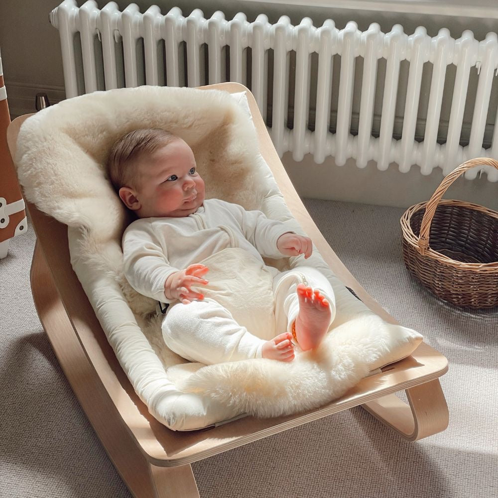 A baby outside on a luxurious sheepskin liner
