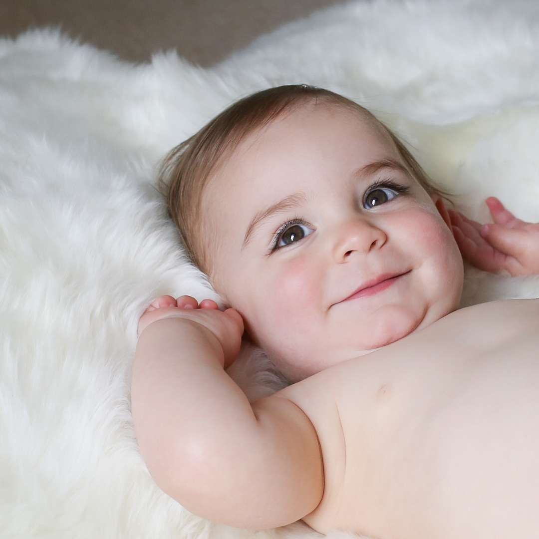 Baby laying on a soft white baby-safe sheepskin rug