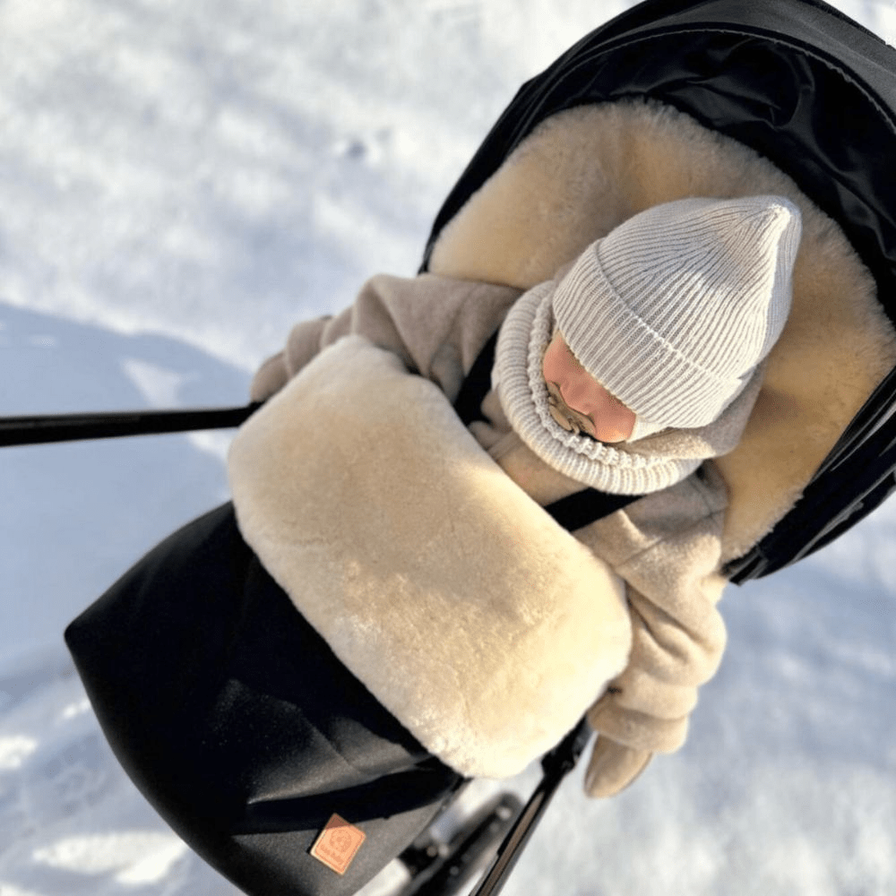 Sheepskin pram footmuff to keep a baby warm in a pram shown in a Nuna Triv fitting perfectly