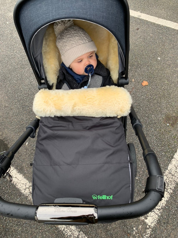 Fully lined and breathable sheepskin pram footmuff with black outer, waterproof and featured in a cybex pram