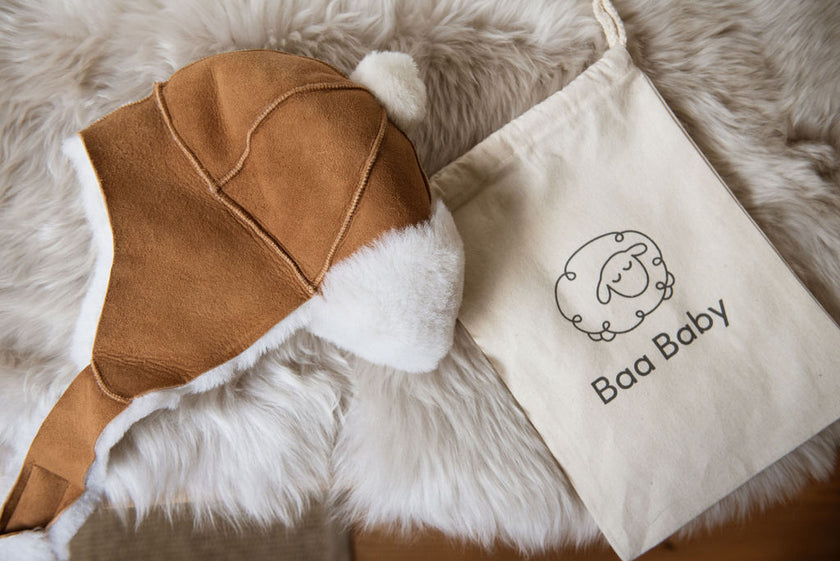 Sheepskin baby trapper hat and bobble hat with flaps to keep ears warm and featured with an eco friendly cotton pouch, natural, sustainable and ethical