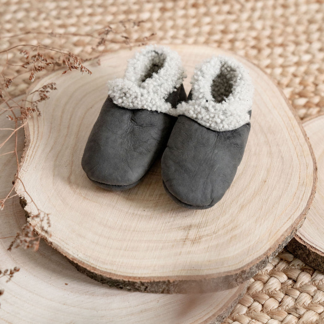 Dark grey lambskin booties on a wooden block, 100% sheepskin sustainability sourced and hand made in new Zealand