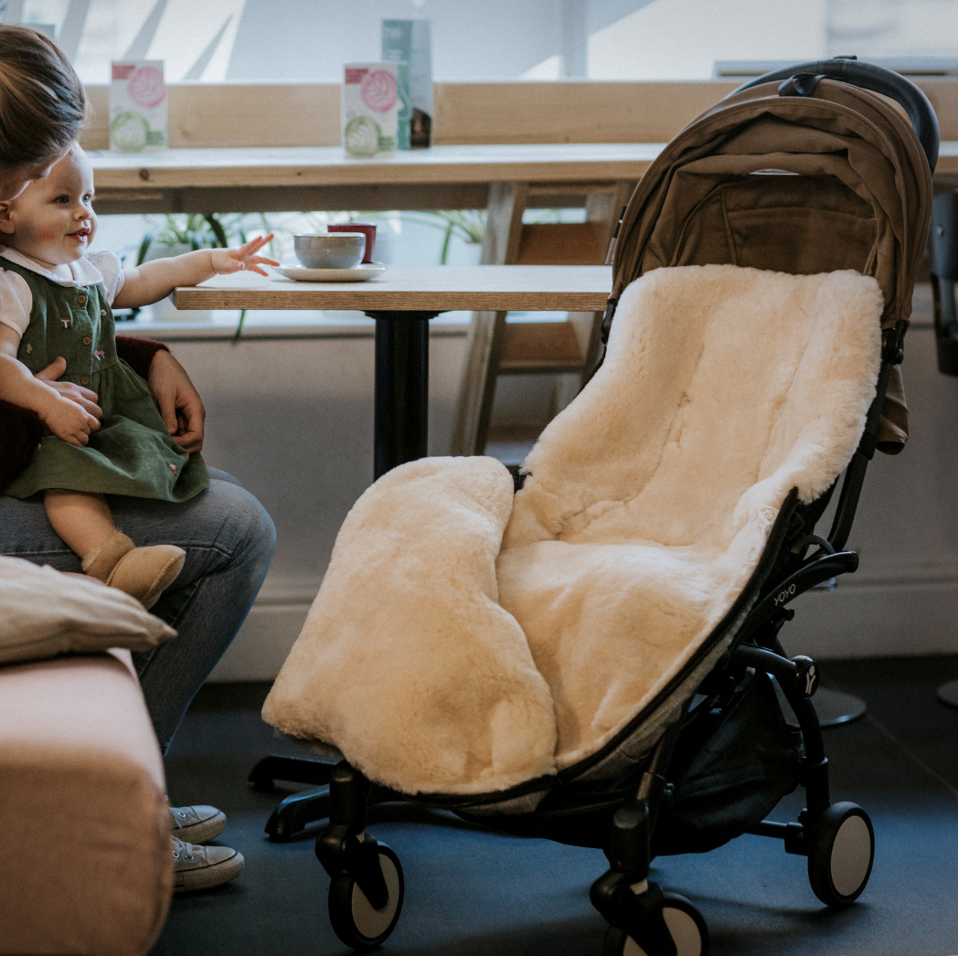 sheepskin footmuff universal fit in a babyzen yoyo, open to show the full lining for a baby to snuggle into 