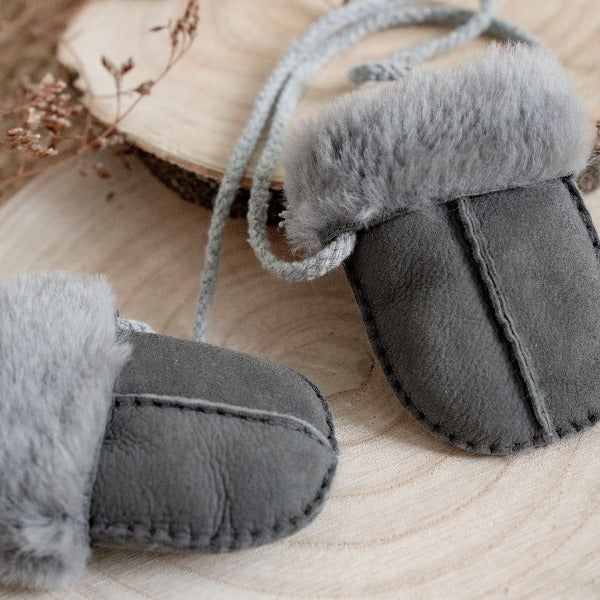 Grey mittens on string with a sheepskin liningfor babies and toddlers 