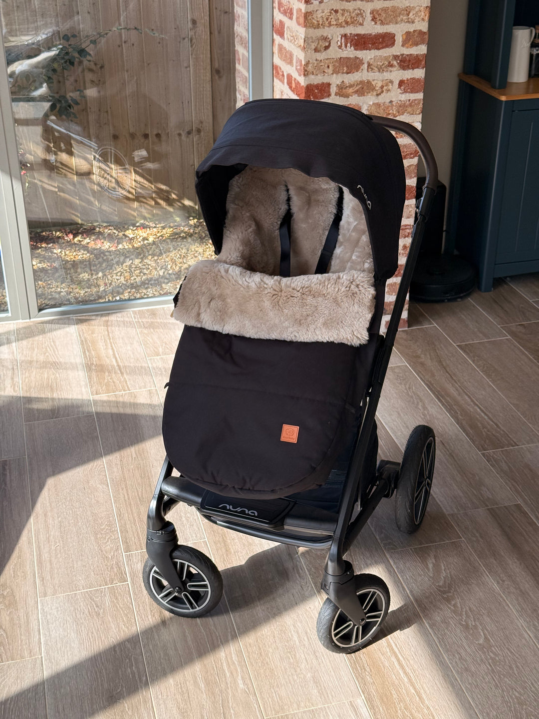 Nuna Mixx in black with a soft sheepskin footmuff lining the pram for warmth