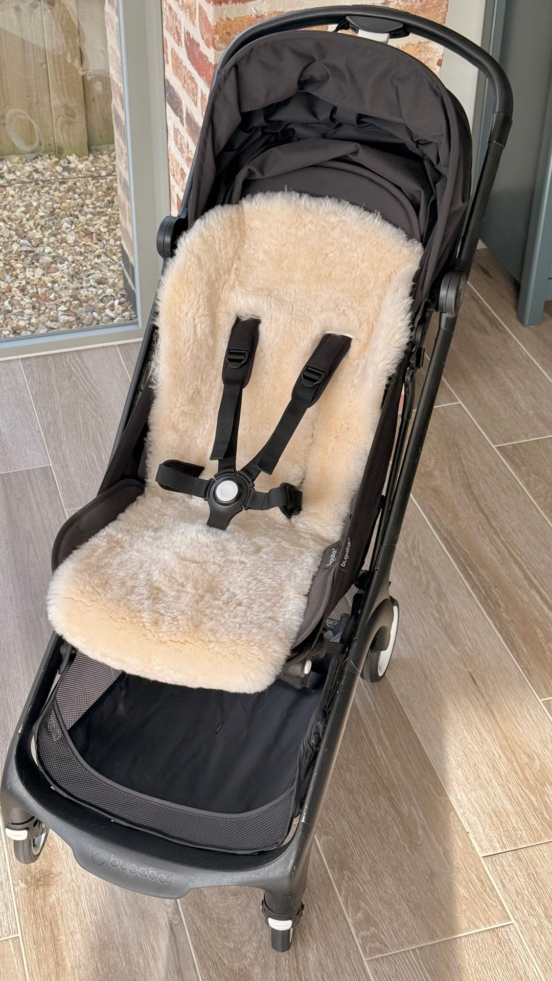 Neutral pale honey and milk sheepskin pram style liner in the bugaboo butterfly travel stroller