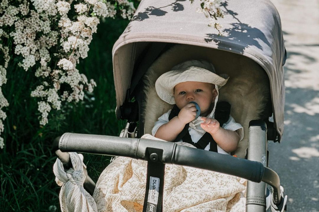 Baby in Bugaboo Fox with a sheepskin liner to keep cool on a spring day