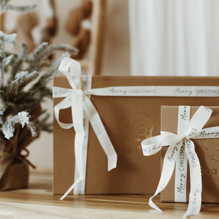 Newborn and Baby Christmas Gifts wrapped in luxury gift boxes with festive ribbon which reads Merry Christmas