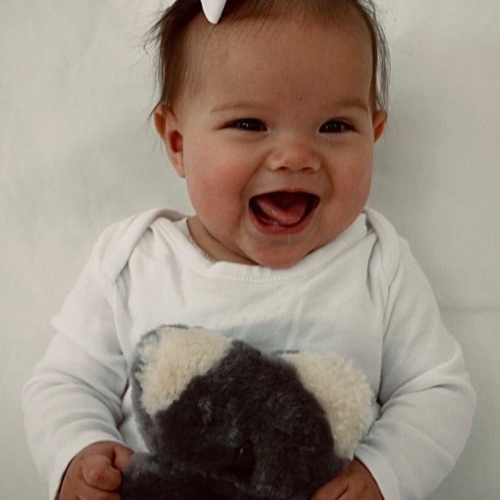Little Girl Holding Sustainable Lambskin Bear Toy for Easy Grip