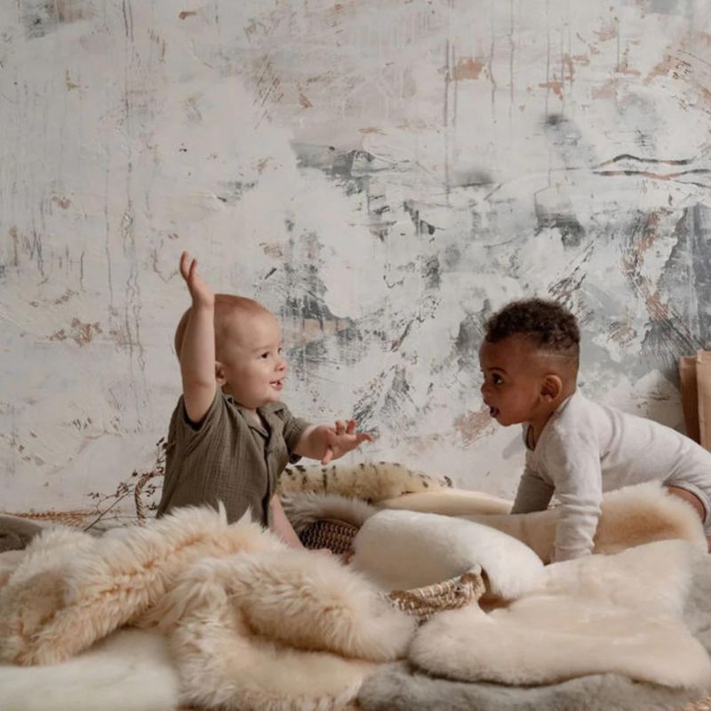 babies crawling on sheepskin rugs in a nursery, soothing and comforting playtime rug for a baby in honey and milk