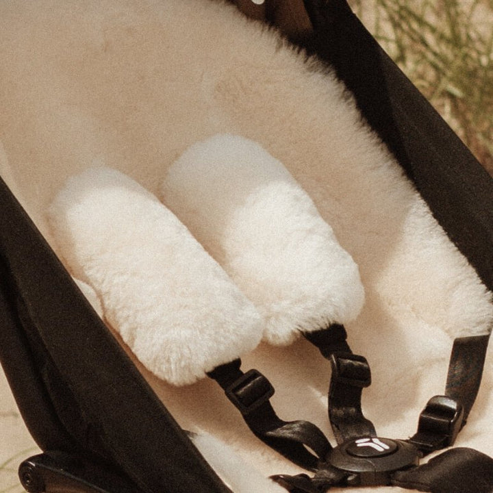 Sheepskin Pram Harness Strap Cover in neutral milk to cushion the straps of a buggy