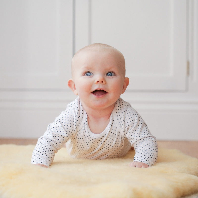 Baby Sitting Comfortably on Kaiser Soft Lambskin Rug in Pale Honey Colour