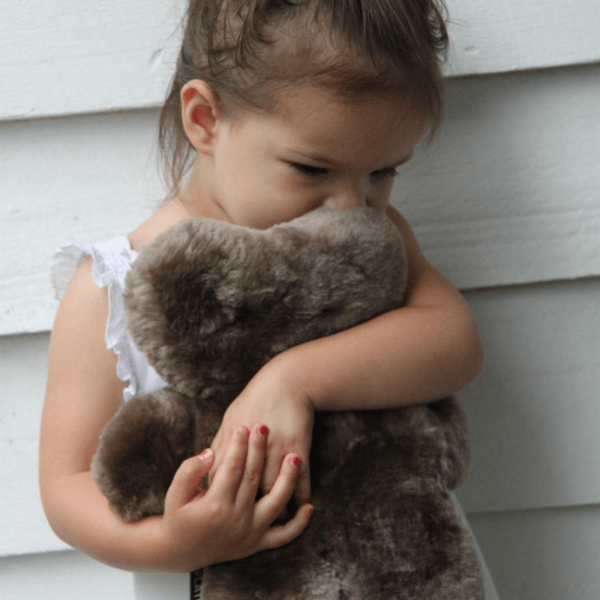 Girl Cuddling an Easy Grip Baby Safe Australian Sheepskin Bear