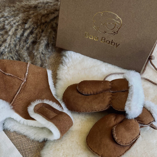 Gift box for babies and toddlers to keep warm in winter with a sheepskin bobble hat and puddy mittens in chestnut on string