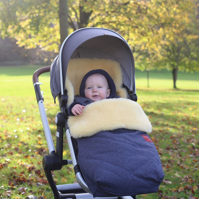 Baby Keeping Warm in Kaiser Natura Cosy Toes Lined with Sustainable Sheepskin in 5 Point Harness Pram